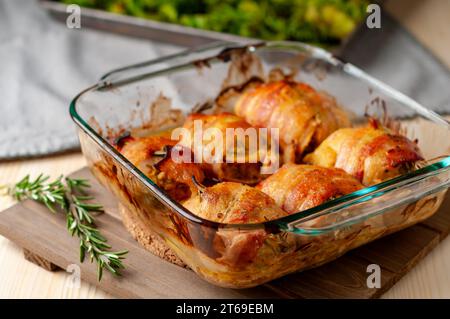Mit Speck umwickelte Honig-Senf-Hähnchenschenkel ohne Haut mit Kräutern und geröstetem Brokkoli Stockfoto