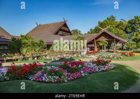 Palmen und Blumengärten unterstreichen die Lanna- und Schweizer Architektur der Doi Tung Royal Villa in der Doi Tung Attraktion in Chiang Rai, Thailand Stockfoto