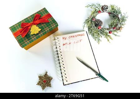 Öffnen Sie den Notizblock mit dem Text für die weihnachtswünsche. Geschmückter weihnachtsbaum auf Hintergrund Stockfoto