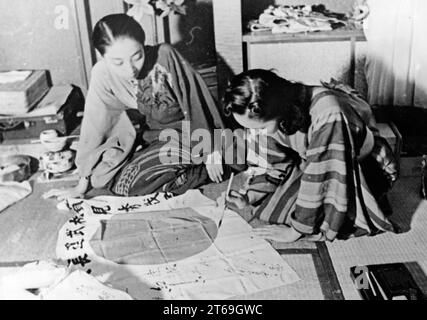 Eine Schauspielerin zeichnet Charaktere auf einer japanischen Flagge. Die Flagge wird einem Soldaten geschickt. [Automatisierte Übersetzung] Stockfoto