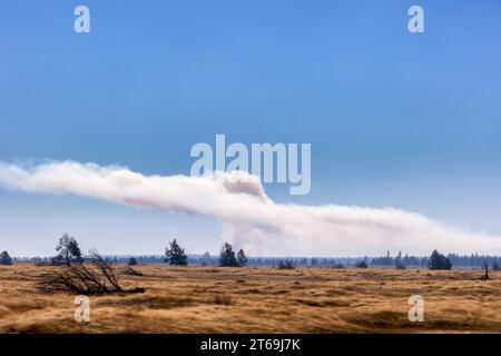 Von einem fahrenden Auto aus kann man in der Entfernung vom Highway 26 im Osten von Oregon, USA, eine kontrollierte Verbrennung beobachten. Stockfoto