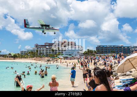 Flugzeug fliegt tief über Maho Beach bei finalem Anflug zum Princess Juliana International Airport auf der Karibikinsel Sint Maarten Stockfoto