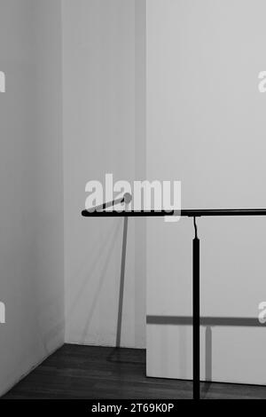 Minimalistischer abstrakter schwarz-weißer Hintergrund mit Stahlstäben an der Wand in einem leeren Raum. Stockfoto