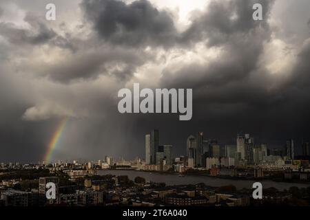 London, Großbritannien. November 2023. Wetter in Großbritannien: Nach einem kurzen Nachmittagsregen bricht ein kurzer Regenbogen in der Nähe der Gebäude des Canary Wharf Business Parks im Osten Londons auf. Guy Corbishley/Alamy Live News Stockfoto