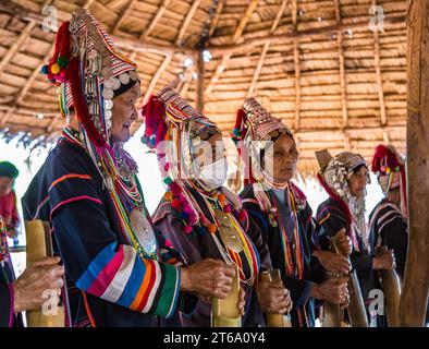 Ältere traditionell gekleidete Menschen spielen musikalische Gesänge in der Gegend der Akha-Stämme der Union of Hill Tribe Villages außerhalb von Chiang Rai, Thailand Stockfoto