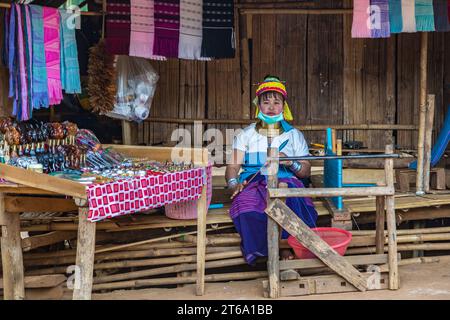 Frau, die Schals und Kunsthandwerk im Gebiet des Long Neck Karen Stammes (Kayah Lahwi Stamm) der Union of Hill Tribe Villages in Chiang Rai, Thailand verkauft Stockfoto