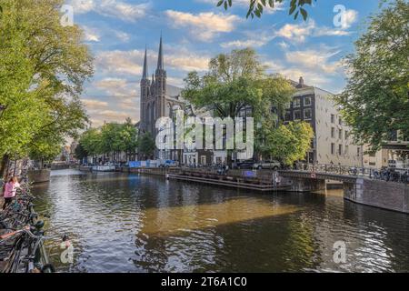 Bild der Kirche St. Franziskus Xavier in Amsterdam mit angrenzendem Kanal tagsüber im Sommer 2023 Stockfoto