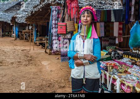 Frau, die gewebte Tücher und anderes Kunsthandwerk in der Gegend des Long Neck Karen-Stammes (Kayah Lahwi-Stammes) der Union of Hill Tribes in Chiang Rai, Thailand verkauft Stockfoto