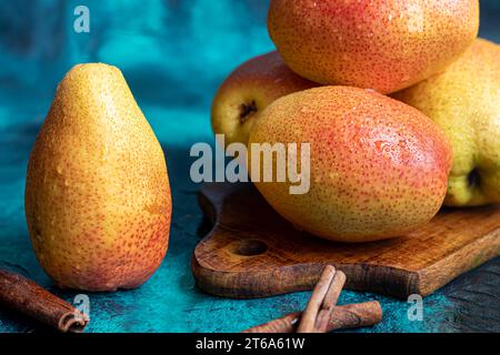 Birnen auf dunklem Hintergrund. Frische, reife Früchte auf blauem Teller und in einer Schachtel. Gesunde Ernährung. Kopierbereich. Stockfoto