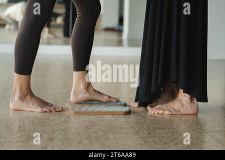 Nahaufnahme der Beine von Mädchen, die barfuß auf einem Brett stehen. Stockfoto