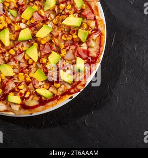 BBQ Chicken Pizza - neapolitanische Soße und Käsebasis. Fusion aus Hühnchen, Speck, Mais, Avocado mit BBQ-Sauce Stockfoto