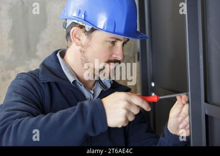 Ein Baumann verschraubt die Wand Stockfoto