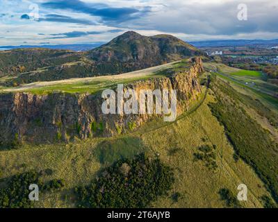 Luftaufnahme der Salisbury Crags mit Arthurs Sitz nach hinten im Holyrood Park, Edinburgh, Schottland, Großbritannien Stockfoto