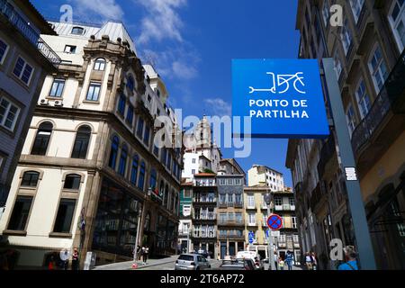 Schild für den gemeinsamen Punkt des Elektrorollers auf der Rua de Ferreira Borges, Kirchturm Igreja da Vitória im Hintergrund, Ribeira, Porto / Porto, Portugal Stockfoto