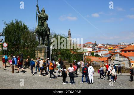 Die Gruppe geht vorbei an der Statue von Vímara Peres, dem Kirchturm Torre dos Clérigos im Hintergrund, Ribeira, Porto/Porto, Portugal Stockfoto