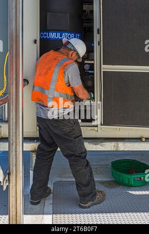 Ein Arbeiter, der in der Kompressorplatte eines CO2-Kühllagers (Industriekühlung) auf dem Dach arbeitet. Stockfoto