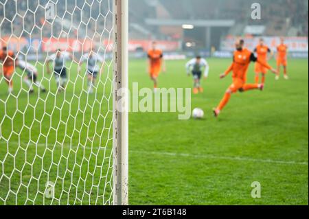 Details zum Torposten mit Netz- und Fußballspieler während des Elfmeterschießes im Hintergrund. Stockfoto