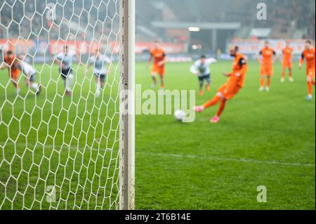 Details zum Torposten mit Netz- und Fußballspieler während des Elfmeterschießes im Hintergrund. Stockfoto