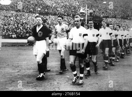 Billy Wright führt das englische Team für sein 100. Länderspiel an, gefolgt von Ronnie Clayton und Ron Flowers. Mit Bobby Evans und Bill Brown aus Schottland. 11/4/59 Stockfoto