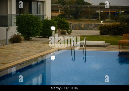 Swimmingpool in der Nähe eines Hauses in einer Wohnanlage bei Sonnenuntergang Stockfoto