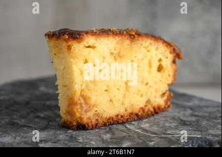 Ein Stück Kuchen mit Orangenmarmelade auf einer Küchenoberfläche aus Stein Stockfoto