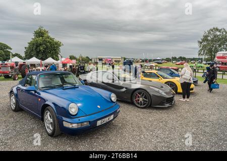 Tarporley, Cheshire, England, 30. Juli 2023. Blaues Porsche 911 Cabriolet und grauer Ferrari F12 bei einem Car Meet, Illustration für den Lifestyle im Automobil. Stockfoto