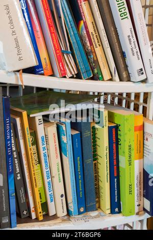 Verschiedene Bücher werden in einem Bücherregal ausgestellt, um in einem Gebrauchtwarengeschäft zu verkaufen. Stockfoto