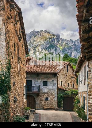 Backstreet im mittelalterlichen Dorf Mogrovejo mit den Europäischen Gipfeln im Hintergrund. In Camaleño, Kantabrien, Spanien Stockfoto