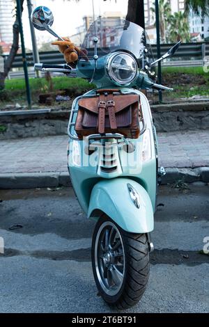 Italienischer Roller mit Ledertasche und auf der Straße geparkt Stockfoto