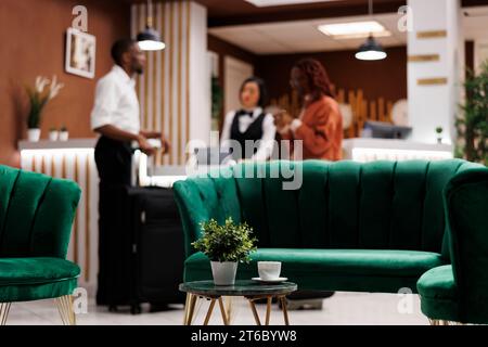 Luxuriöser Loungebereich an der Rezeption mit Couch, auf der Gäste vor dem Check-in sitzen können. Eingang in die Hotellobby mit Rezeption, an der Gäste Unterbringung erhalten und Reservierungen buchen können. Stockfoto