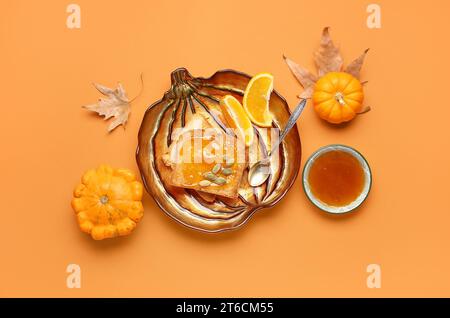 Teller mit süßer Kürbismarmelade und Samen auf orangefarbenem Hintergrund Stockfoto