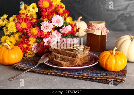 Teller Toast mit süßer Kürbismarmelade und Samen auf grauem Tisch Stockfoto