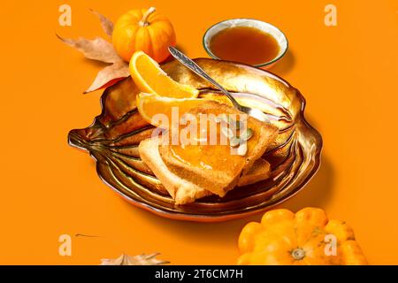 Teller mit süßer Kürbismarmelade und Samen auf orangefarbenem Hintergrund Stockfoto