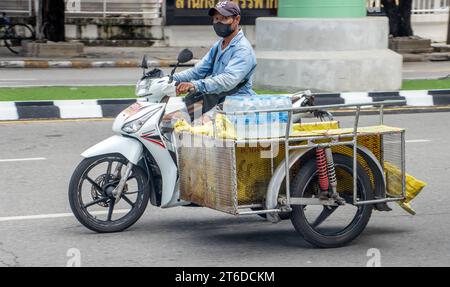 SAMUT PRAKAN, THAILAND, 11. Oktober 2023, Ein Mann fährt Motorrad mit einem beladenen Beiwagen Stockfoto