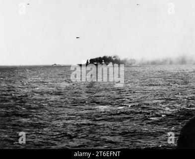 Die USS Lexington (CV-2) steht in Flammen und unten am Bug, wird aber während der Schlacht am Korallenmeer am 8. Mai 1942 unterwegs sein Stockfoto