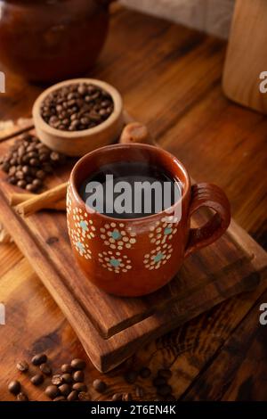 Cafe de Olla, mexikanischer Kaffee mit gerösteten und gemahlenen Kaffeebohnen, Zimt und Piloncillo. Traditionelles Rezept, zubereitet in einem Tontopf A Stockfoto