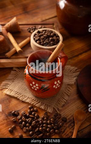 Cafe de Olla, mexikanischer Kaffee mit gerösteten und gemahlenen Kaffeebohnen, Zimt und Piloncillo. Traditionelles Rezept, zubereitet in einem Tontopf A Stockfoto