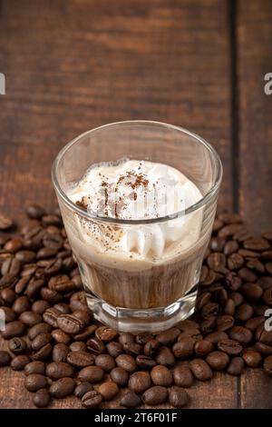 Heißer Espresso mit Panna in Glasbecher auf Holztisch Stockfoto
