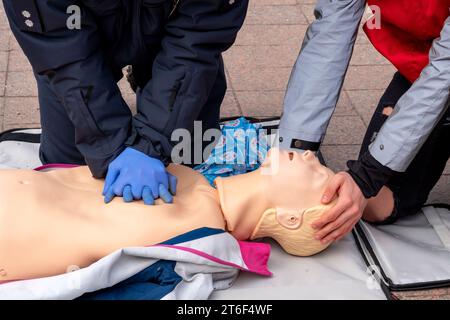 Hände eines Polizisten an einer Schaufensterpuppe während einer Reanimationsübung. HLW-erste-Hilfe-Schulungskonzept.Notfallversorgung. Stockfoto