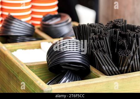 Die Ränge der Papierkurben. Kaffeegläser. Wand aus Tassen aus Pappe. Kunststoffbecher, Deckel, Strohhalme, Röhrchen Stockfoto