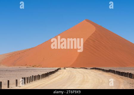 Eine weitläufige Wüstenlandschaft mit einer großen, hoch aufragenden Sanddüne im Zentrum der Szene Stockfoto