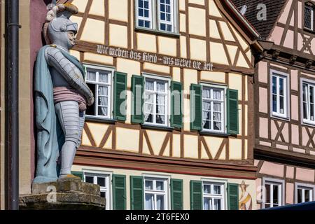 Mittelalterliche Ritterskulptur an der Fassade einer Hausecke gegenüber der Hangman's Bridge mit Rüstung, Helm und Schwert und Fachwerkhäusern Stockfoto