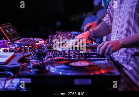 Hip-Hop-DJ kratzt Schallplatten auf Plattenspielern. Diskjockey mischt Musik auf Konzert Stockfoto