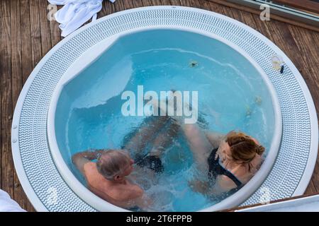 Ein paar Passagiere entspannen sich im Whirlpool an Bord der Hurtigruten MS Richard mit einem Kreuzfahrtschiff in Norwegen, Skandinavien, Europa im Oktober Stockfoto