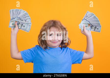 Geld gewinnen, viel Glück. Amerikanische Träume. Junge, der Geldscheine zeigt, träumt von Reichen vor isoliertem gelbem Studiohintergrund. Stockfoto