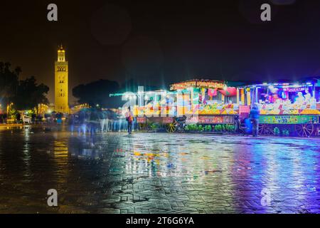 Marrakesch, Marokko - 04. April 2023: Regnerische Nachtszene auf dem Platz Jemaa el-Fnaa mit verschiedenen Verkaufsständen, Einheimischen und Besuchern in Marrakesch, Marokko Stockfoto