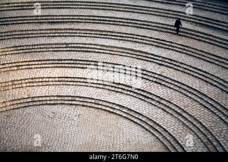 Ein Mann, der Treppenstufen außerhalb der Roman Colosseum at El Jem (El Djem), das drittgrößte Kolosseum in der Welt. Stockfoto