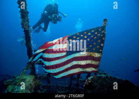 Underwaer-Videograf untersucht die amerikanische Flagge, die majestätisch über dem Schiffswrack des USCG-Schneiders Duane, Key Largo, Florida, fliegt Stockfoto