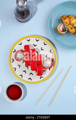 Kalifornische Maki-Rolle mit Tobiko-Kaviar auf farbigem Hintergrund Stockfoto