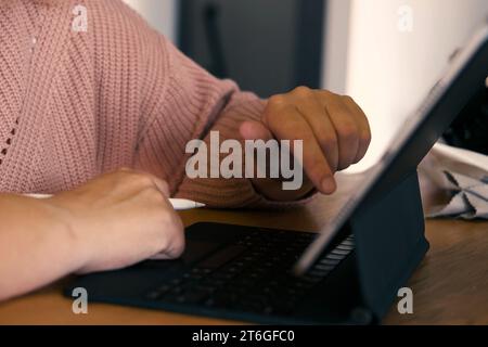 Unerkennbare Frauenhand mit einem Grafiktablett-Computer mit Stift-Stift in einem Café. Zugeschnittene Aufnahme einer Frau, die auf einem digitalen Touchscreen arbeitet DE Stockfoto